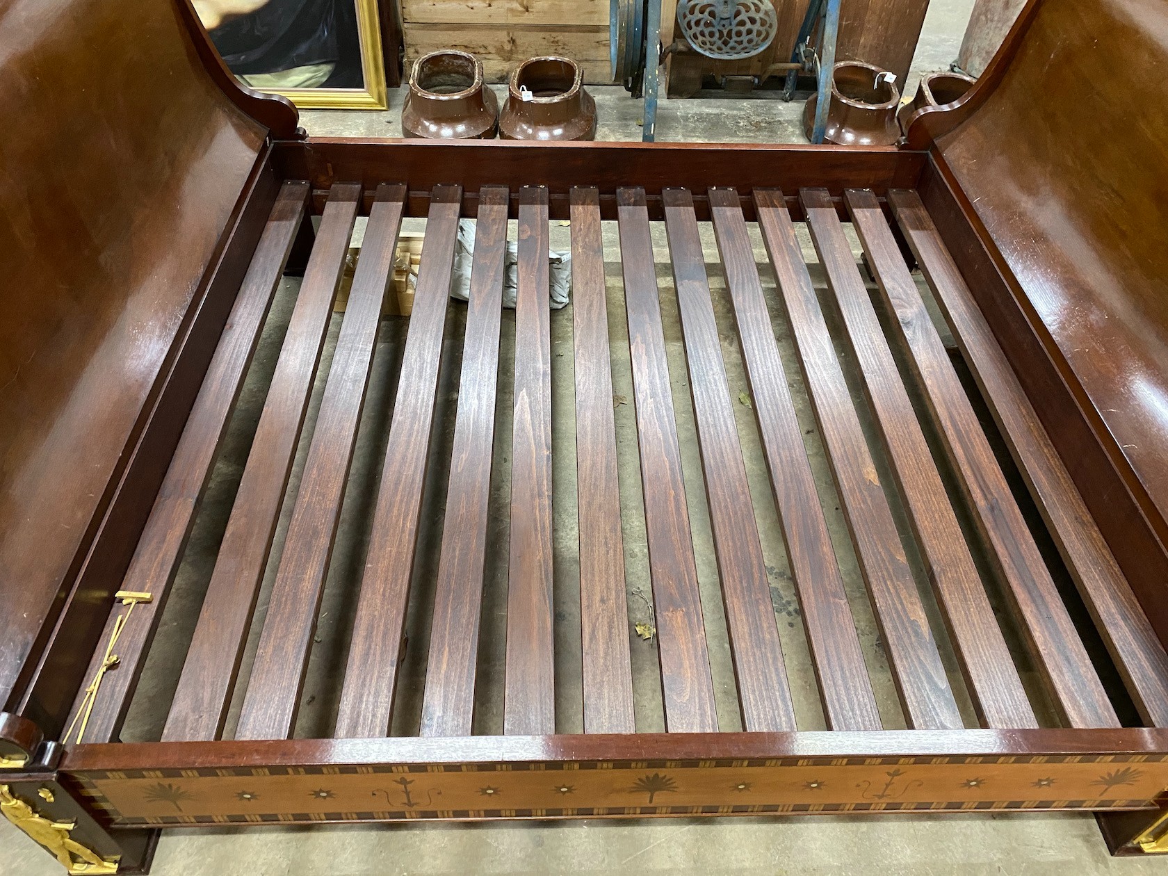 A reproduction Egyptian style inlaid gilt metal mounted mahogany sleigh bedframe, width 193cm, length 261cm, height 110cm